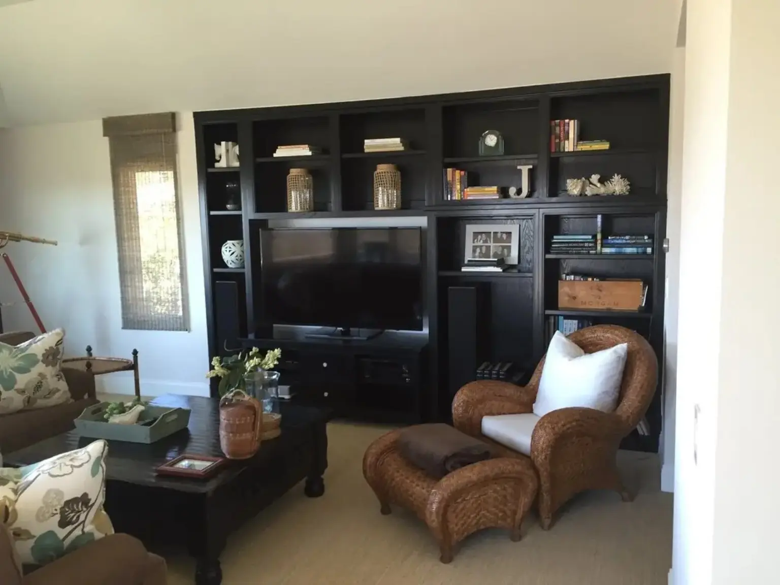Completed dark-stained full-wall entertainment built-in with integrated shelving and media storage