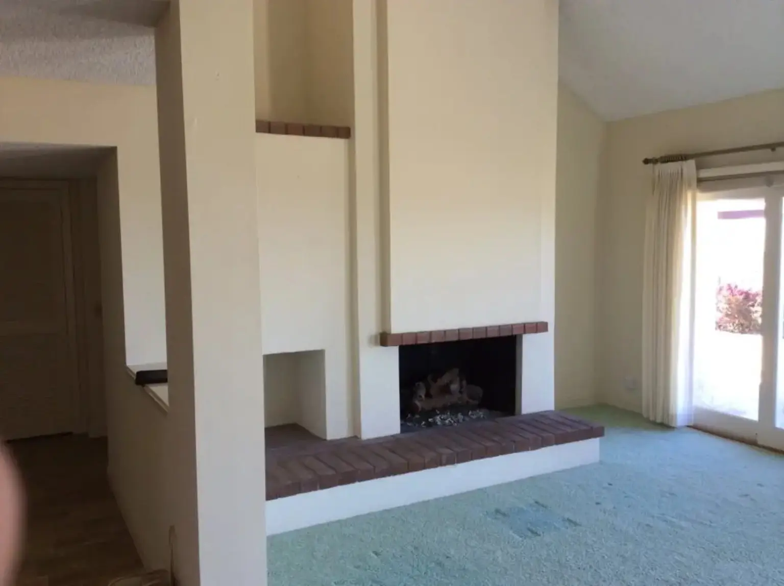 Living room before renovation with a simple raised brick fireplace