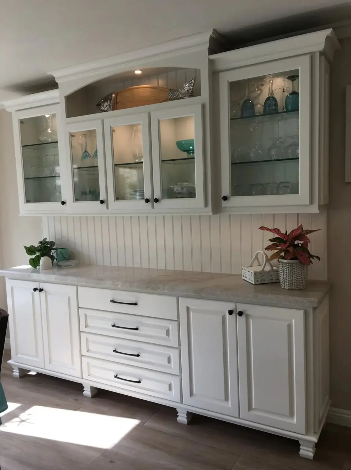 Completed custom white built-in cabinetry with glass-front display cabinets