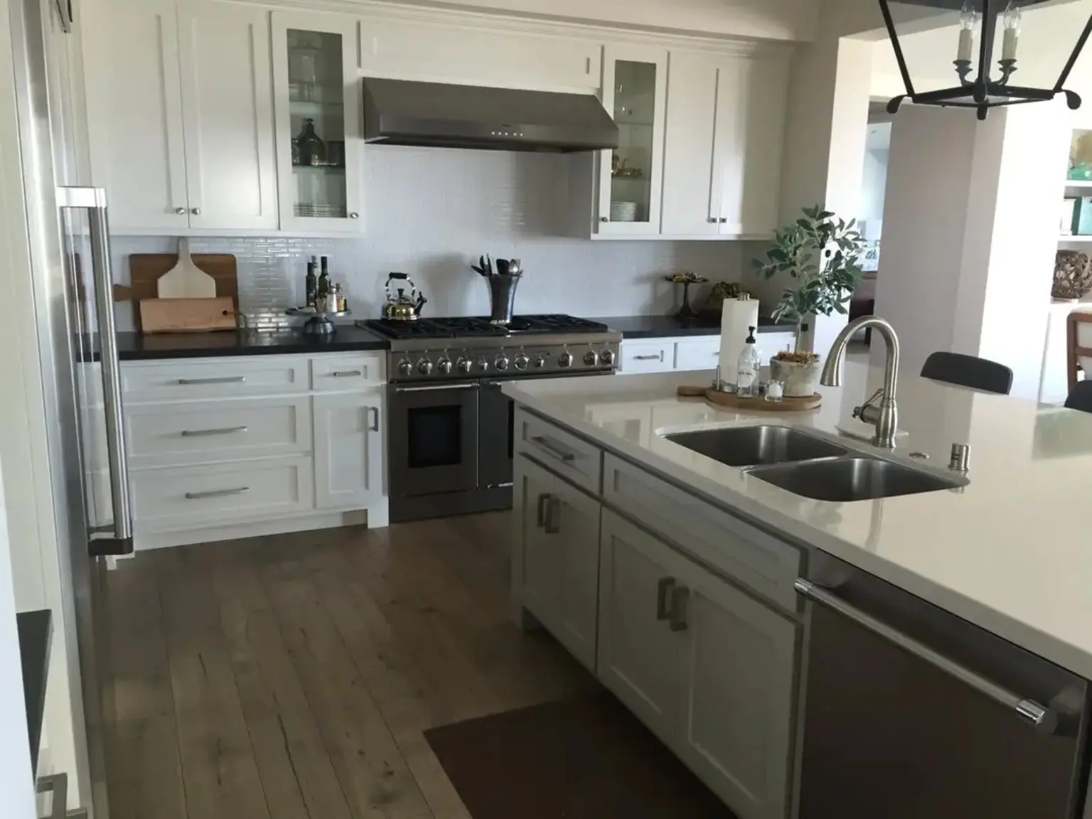 Completed JBI kitchen renovation with white custom cabinetry, professional range, and island