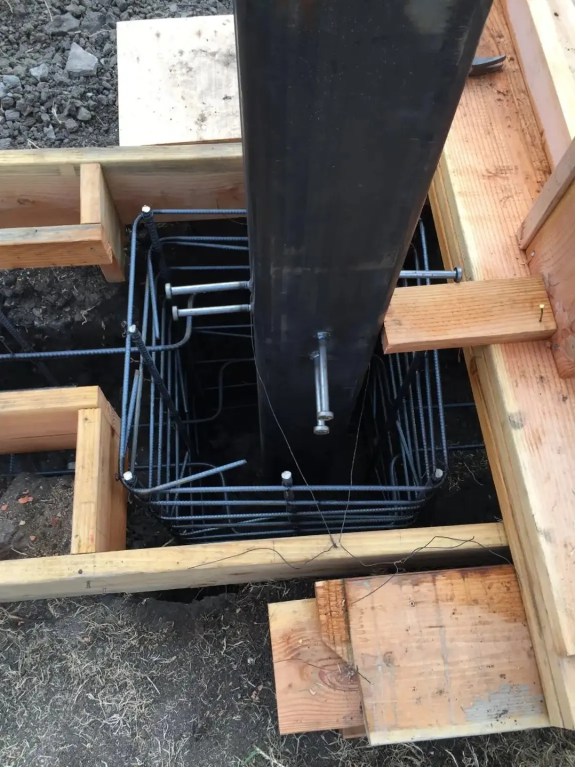 Close view of steel structural support set within reinforced footing formwork